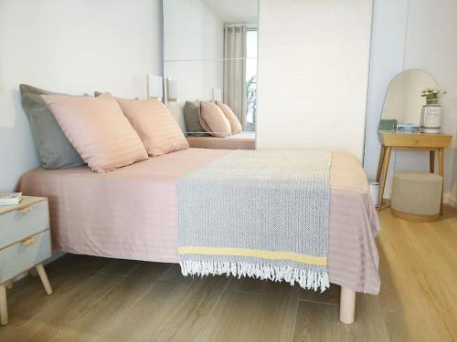 - une chambre avec un lit doté d'oreillers roses et d'un miroir dans l'établissement Chez L'Hadriana, 2x AC clim Wi-Fi,newly renovated, à Nice