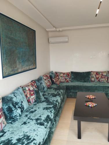 a living room with a couch and a table at TILILA APARTMENT TANGIER - Panoramic View in Noûnouech