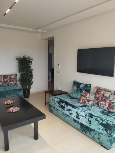 a living room with a couch and a table at TILILA APARTMENT TANGIER - Panoramic View in Noûnouech