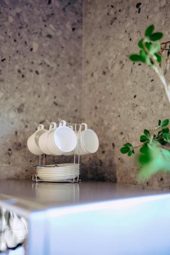 a group of white plates and bowls on a table at CBD Contemporary Comfort Townhouse 2 Bed 2Bath in Christchurch