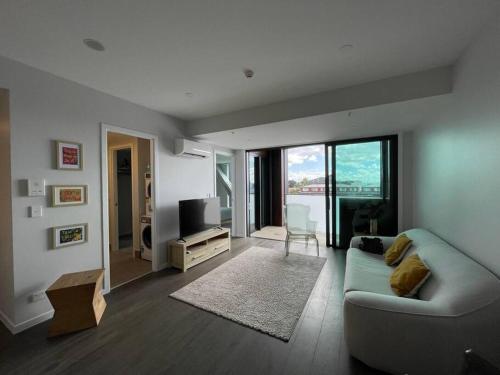 a living room with a couch and a television at No 1 Location in Mt Eden! in Auckland