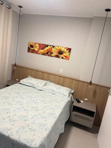 a bedroom with a bed and a picture on the wall at Cobertura 402- 2 Dormitórios Praia de Bombas in Bombas