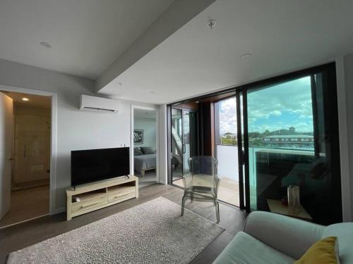 a living room with a couch and a television at No 1 Location in Mt Eden! in Auckland