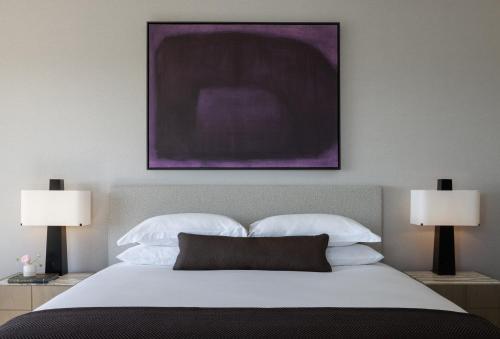 a bedroom with a bed with a purple painting on the wall at Kimpton Claret Hotel by IHG in Denver