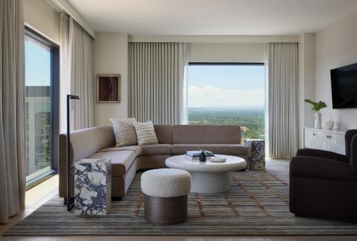 a living room with a couch and a table at Kimpton Claret Hotel by IHG in Denver