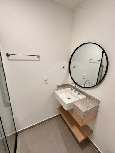 a bathroom with a sink and a mirror at Studio a 500 metros do Allianz Parque, moderno, com piscina e academia in Sao Paulo