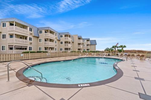 マートルビーチにあるSalt Lifeのアパートメントの建物の前にスイミングプールがあります。