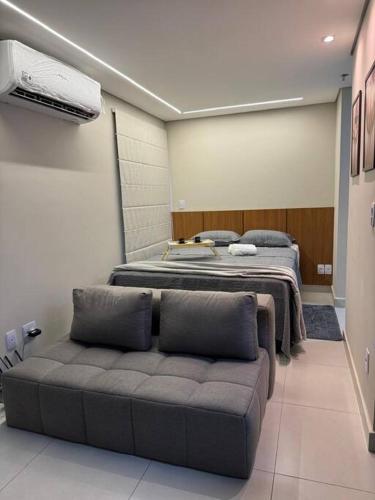 Una habitación con dos camas y un sofá. en Apartamento 106 - Moderno, en Ribeirão Preto