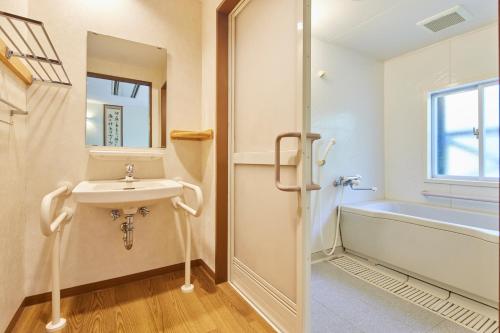 a bathroom with a sink and a bath tub at Kamenoi Hotel Aso Park Resort in Aso