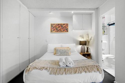 墨尔本Beach-Side Studio Apt with parking spot的一间卧室配有一张床,并备有2个拖鞋