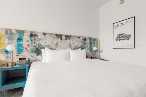 a bedroom with a large white bed and a blue table at The Doyle Hotel in Charlottesville