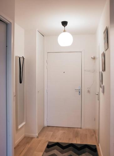 un couloir avec une porte blanche et un tapis dans l'établissement Le Senghor, Évry-Courcouronnes