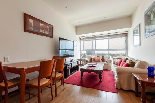 a living room with a table and a couch at Beautiful apartment w/amenities in front of CARSO in Mexico City