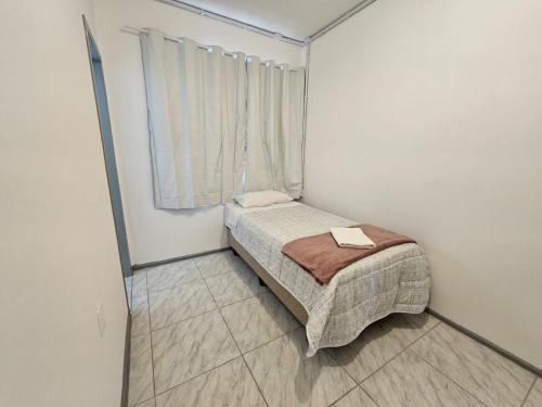 a small bedroom with a bed and a window at Hotel Rex in Lages