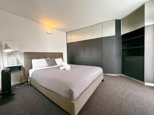 a bedroom with a large white bed with a large closet at Cityside Beautiful Lodge - close to City & Airpor in New Town