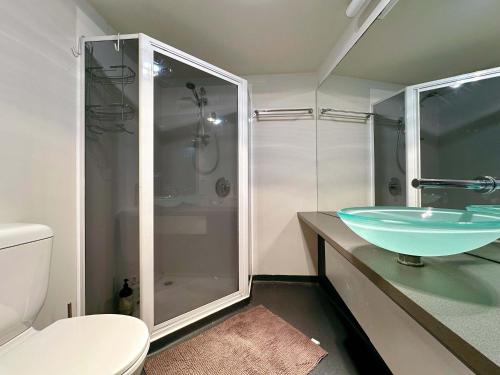 a bathroom with a glass sink and a shower at Cityside Beautiful Lodge - close to City & Airpor in New Town