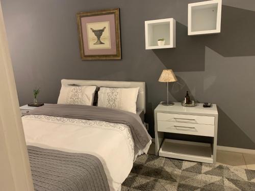 a bedroom with a bed and a night stand with a lamp at Flat Leblon inn in Rio de Janeiro