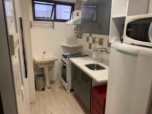 a small white kitchen with a sink and a sink at Flat Leblon inn in Rio de Janeiro