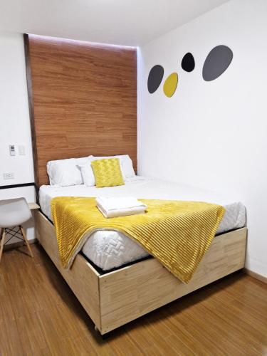 a bedroom with a large bed with a wooden headboard at Amplia, Moderna y Elegante Cerca Tikal Futura y Miraflores H8 in Guatemala