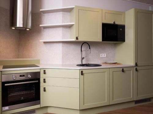 a kitchen with white cabinets and a sink at Nature Escape Bungalow in Antoing