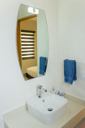 a bathroom with a white sink and a mirror at Casa con alberca cerca de playas Riviera Nayarit in Naranjo