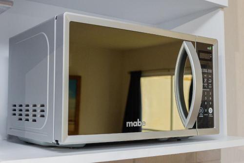 a microwave oven sitting on top of a shelf at Casa con alberca cerca de playas Riviera Nayarit in Naranjo