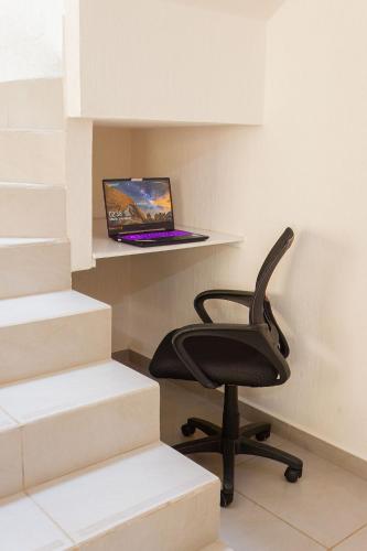 a black chair sitting next to a laptop on a shelf at Casa con alberca cerca de playas Riviera Nayarit in Naranjo