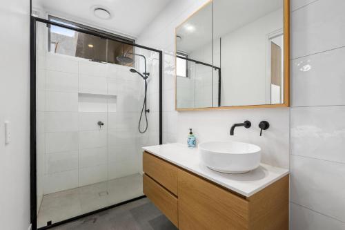 a white bathroom with a sink and a shower at Banksia Coastal Retreat in Point Lonsdale