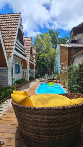 a large wicker hammock next to a swimming pool at VILLAM AREIA FOFA in Bombinhas