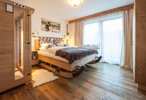 una camera con un grande letto e una grande finestra di Alpineas a Leutasch