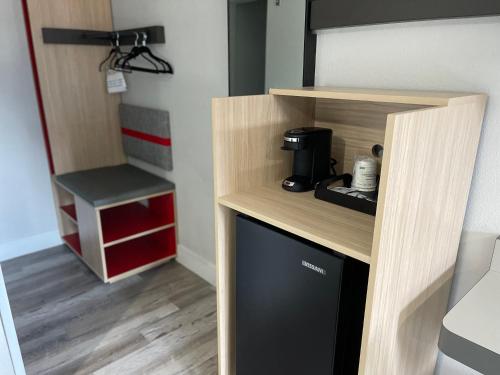 a small kitchen with a coffee maker in a room at The Midtowner Hotel, SureStay Collection by Best Western in Sacramento