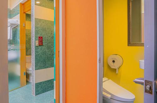 an orange bathroom with a toilet and a shower at Regale Motel in Zhonghe