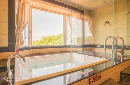 a large bath tub in a kitchen with a window at Regale Motel in Zhonghe