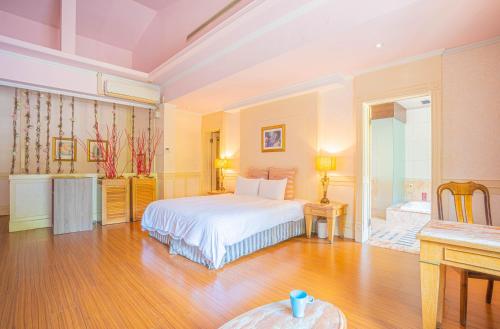 a bedroom with a white bed and a table at Regale Motel in Zhonghe