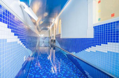 a bathroom with a blue tiled floor and a window at Regale Motel in Zhonghe