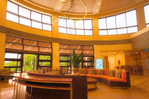 a lobby with couches and tables and windows at PICO DE LORO Nearest to Pool JACANA 1 Bedroom Units by SEE Condominiums in Cutad