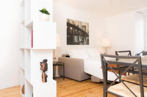 een woonkamer met een bank en een bed bij Beautiful Studio in Historic Alfama in Lissabon