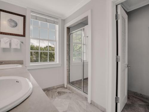 a white bathroom with a toilet and a window at Valentines Resort & Marina in Harbour Island