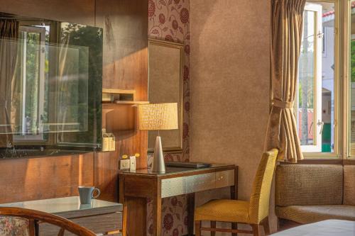 a room with a desk and a chair and a mirror at Regale Motel in Zhonghe