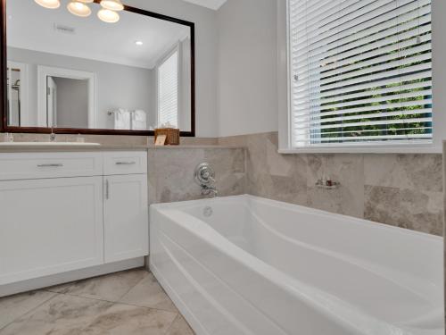 a white bathroom with a tub and a sink at Valentines Resort & Marina in Harbour Island