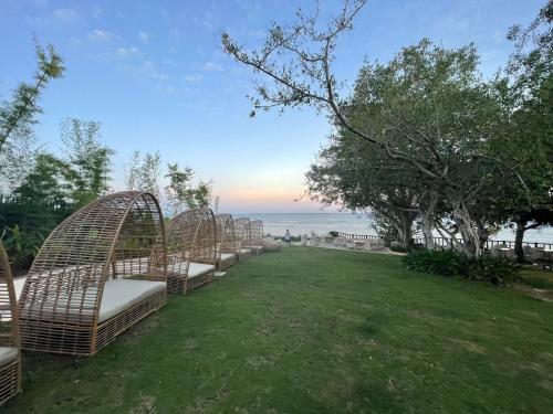 a row of benches in a field with the ocean at Mactan Newtown 8 Boulevard Deluxe Ocean View in Lapu Lapu City