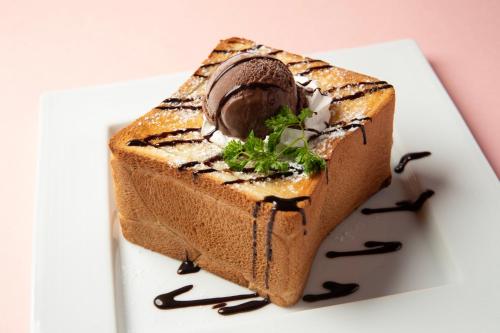 a piece of cake with chocolate on a white plate at ホテル ブルジュア 久留米 Hotel Bvljua -レジャーホテル- in Kurume
