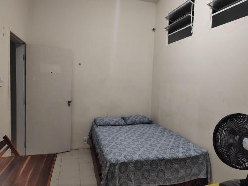 a small bedroom with a bed and a fan at Bela Vista in São Luís