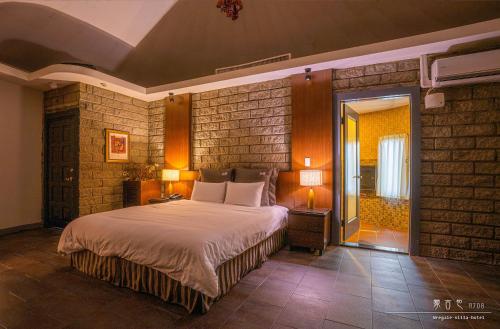 a bedroom with a bed and a brick wall at Regale Motel in Zhonghe