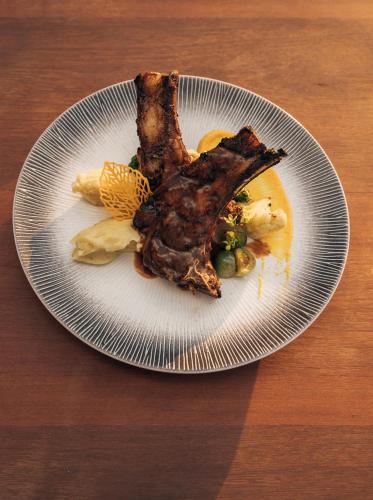 a plate of food with a piece of meat and vegetables at Anna Villas by Sumba-Beach in Memboro