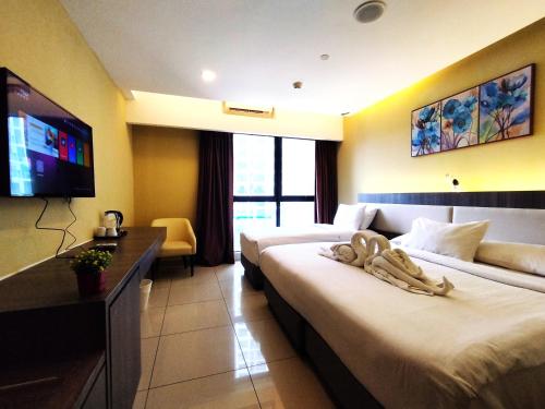 a hotel room with two beds and a flat screen tv at Genting GetawayStayCationHut AT Ion Delemen in Genting Highlands