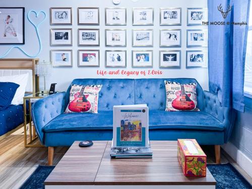 a living room with a blue couch and a table at The Moose #4 - Elvis Presley King Suite with Free Parking and WIFI in Memphis