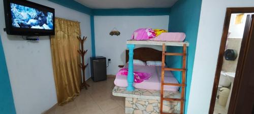 una stanza con un letto a castello e una televisione di Buzios Posada a Chichiriviche
