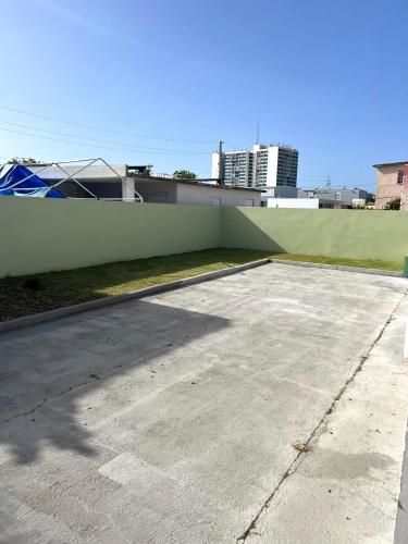 an empty parking lot next to a green wall at Home Aire Familiar in Toa Baja