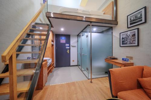 a room with a loft bed and a staircase at QiQiaoWu Fashion Hotel - Beijing Songjiazhuang Subway Station in Beijing